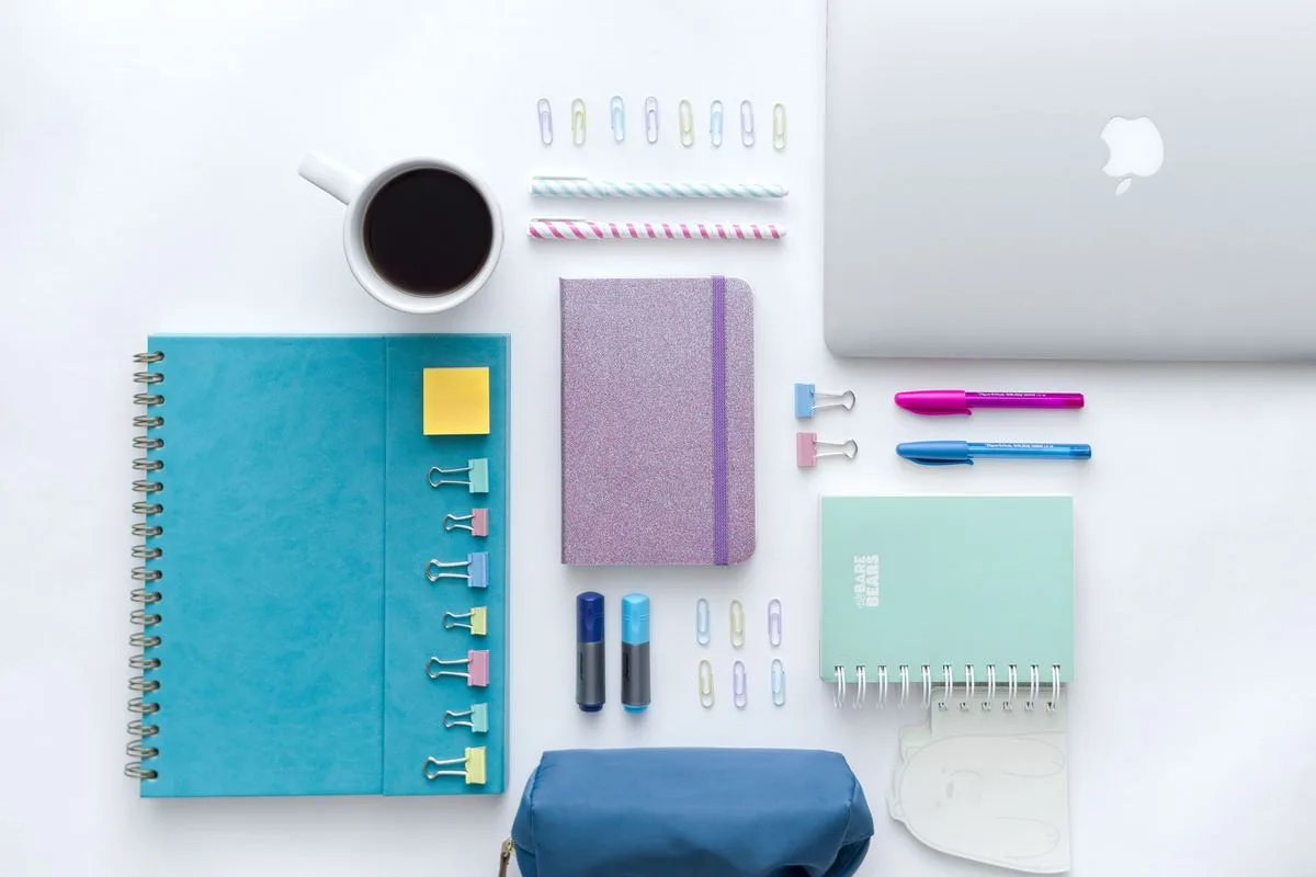 Colourful, organised desk with notebooks, pens and a planner
