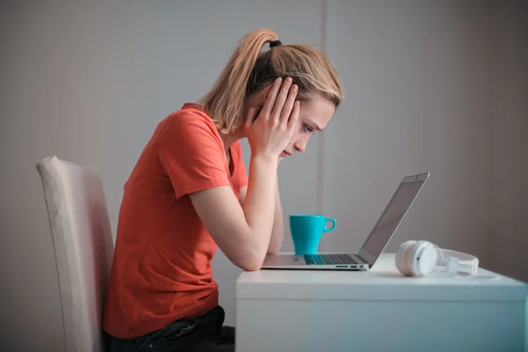 Person experiencing the exhaustion of managing OCD alongside work demands
